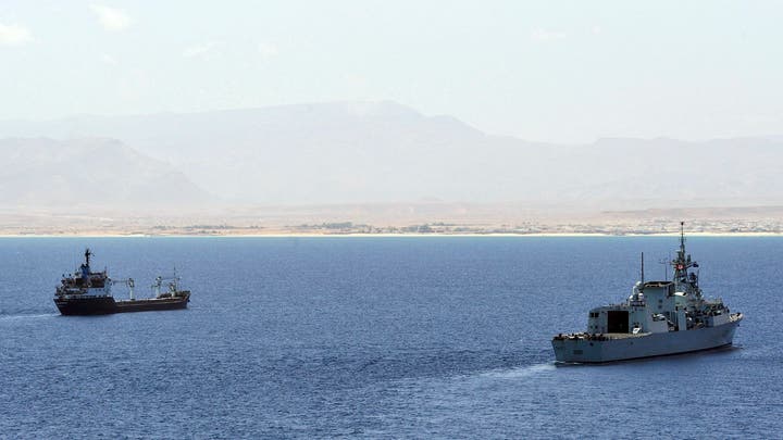 A commercial cargo ship docked at an industrial port harbor.